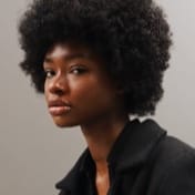 3/4 view of an african black woman with an afro staring into the camera